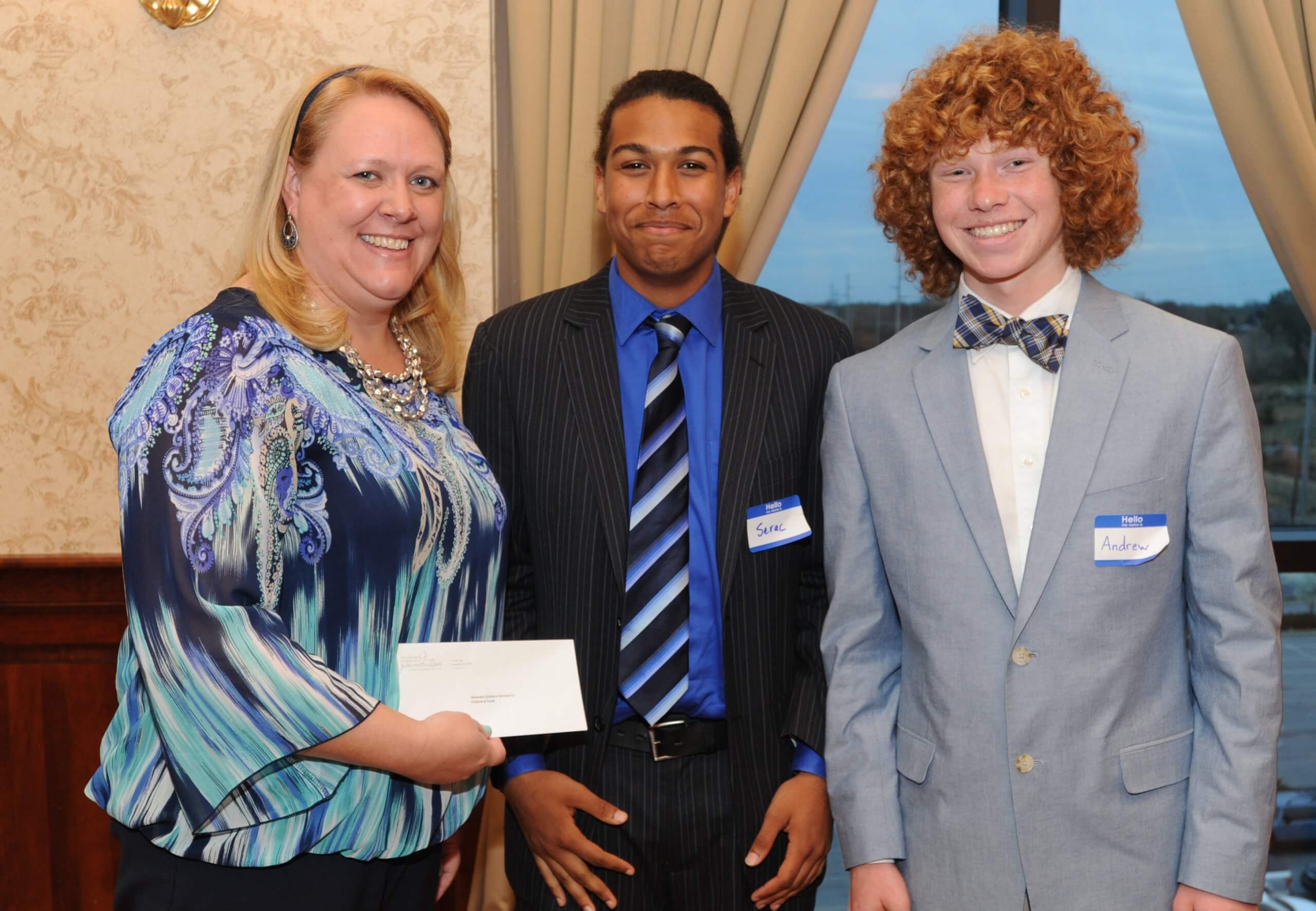 Christy Pennington of Delaware Guidance Services for Children and Youth accepts a Youth Philanthropy Board grant from Smyrna High School seniors Serac McClenton (center) and Andrew Morrison.