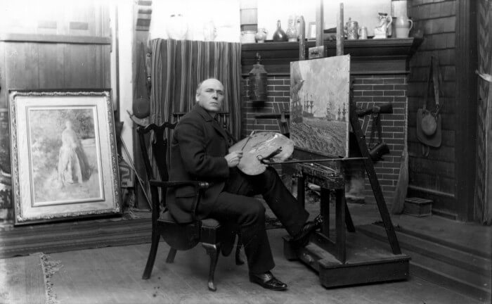 The artist Howard Pyle painting in his studio
